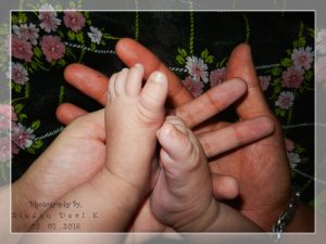 Our Little Wonder's Cute Little Feet in Our Hands